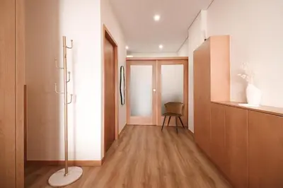 a room with a hallway with wooden floors and a chair at Bleu Alma Apartment in Porto
