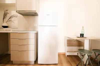 a kitchen with a refrigerator and a table and chairs at Bleu Alma Apartment in Porto