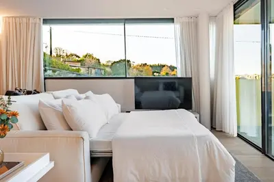 a bedroom with a white bed and a large window at Quinta de Sao Marcos Suite Deluxe in Vila Nova de Gaia