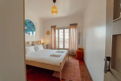 a bedroom with a bed and a large window at Santa Catarina Flat 2BD with Balcony by Vacationy in Porto