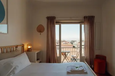 a bedroom with a bed and a view of a balcony at Santa Catarina Flat 2BD with Balcony by Vacationy in Porto