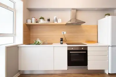 a kitchen with white cabinets and a stove at Santa Catarina Haven by LovelyStay in Porto