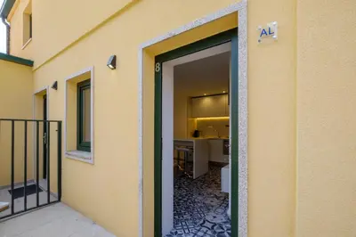 a living room with a chair and a kitchen at Cozy Downtown House in Porto