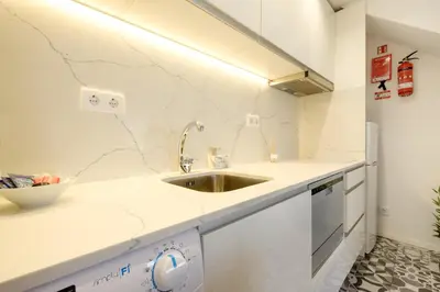 a kitchen with white counters and a sink at Cozy Downtown House in Porto