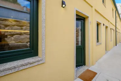 a green door on the side of a building at Cozy Downtown House in Porto