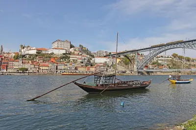 a boat in the water in front of a bridge at FLH Porto Modern Flat in Porto