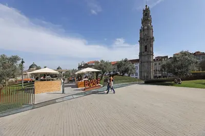 a couple of people walking down a street with a clock tower at FLH Porto Modern Flat in Porto