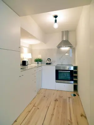 a kitchen with white appliances and a wooden floor at FLH Porto Modern Flat in Porto