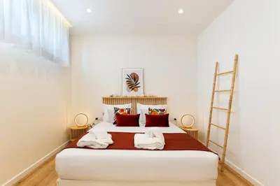 a bedroom with a bed with red pillows and a ladder at GuestReady - Urban retreat in Porto in Porto