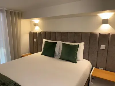 a bedroom with a large bed with two green pillows at Jardins de Cedofeita Apartment by Oporto Soul in Porto