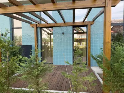 a wooden deck with a pergola in a garden at Jardins de Cedofeita Apartment by Oporto Soul in Porto