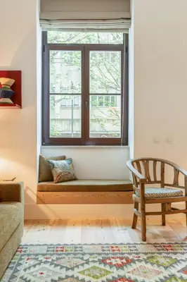 a window seat in a living room with a chair at Luxurious Flat in Award-Winning Building in Porto
