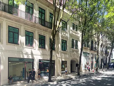 a group of people walking down a street next to a building at Luxurious Flat in Award-Winning Building in Porto