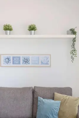 a white shelf above a couch with plants on it at Liiiving in Gaia - Douro Balcony View in Vila Nova de Gaia