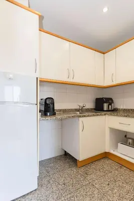 a kitchen with white cabinets and a white refrigerator at Liiiving in Gaia - Douro Balcony View in Vila Nova de Gaia