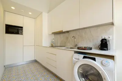 a kitchen with a washing machine and a sink at Magnolia 5 Luxury with AC Metro Downtown Porto in Porto