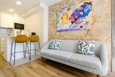 a living room with a couch and a painting on the wall at Magnolia 1 Luxury with AC Metro Downtown Porto in Porto