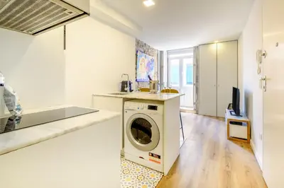 a kitchen with a washing machine in a white kitchen at Magnolia 1 Luxury with AC Metro Downtown Porto in Porto