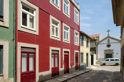 a red building with red doors on a street at Magnolia 1 Luxury with AC Metro Downtown Porto in Porto