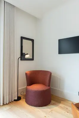 a chair in a room with a lamp and a mirror at Chic 1-BR Flat in Award-Winning Building in Porto