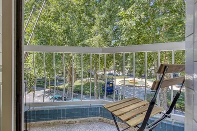 a rocking chair on a screened porch with a view of a park at OPORTO GUEST Marquês Square in Porto