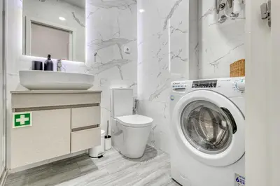 a bathroom with a washing machine and a sink at OPORTO GUEST Marquês Square in Porto