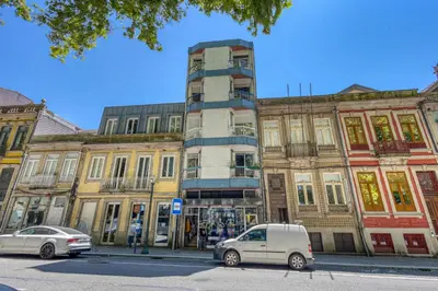 a building with two cars parked in front of it at OPORTO GUEST Marquês Square in Porto