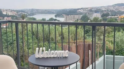 a table on a balcony with a view of a city at RIVER VIEW TMB oporto station house in Porto