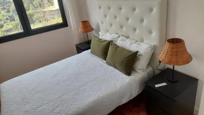 a bedroom with a white bed with two lamps at RIVER VIEW TMB oporto station house in Porto