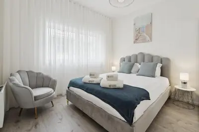 a bedroom with a large bed and a chair at GuestReady - An elegant stay in the city centre in Porto