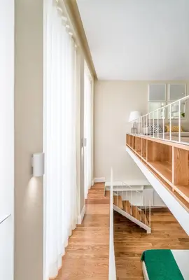 a staircase in a room with white walls and wood floors at Mouzinho 160 in Porto