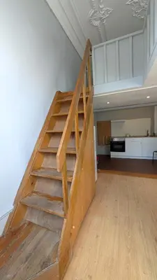 a wooden staircase in a living room with at Riko Guesthouse in Porto