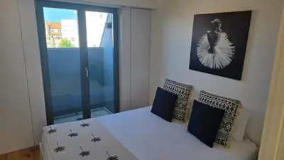a bedroom with a bed with blue pillows and a window at Fontainhas Sunny Rooftop with balcony in Porto