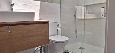 a bathroom with a toilet and a glass shower at Fontainhas Sunny Rooftop with balcony in Porto