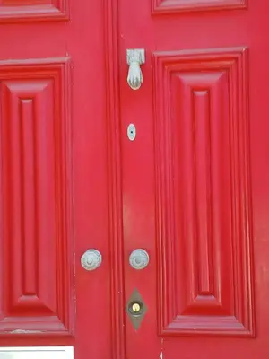 a red door with silver knockers on it at Top of the World by Upperground in Porto