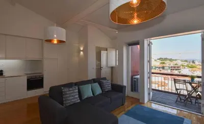 a living room with a couch and a kitchen at Top of the World by Upperground in Porto