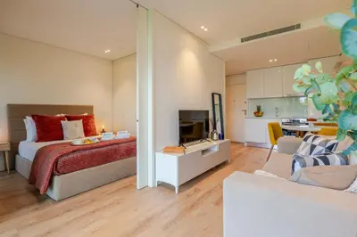 a bedroom with a bed and a living room at Studio w/ Balcony, Pool & Gym in Antas by HostWise in Porto