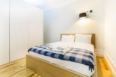 a bedroom with a bed with a blue and white blanket at Avantgarde by Upperground in Porto