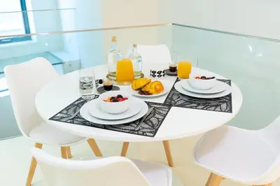 a white table with breakfast foods and orange juice at Douro River by Upperground in Porto