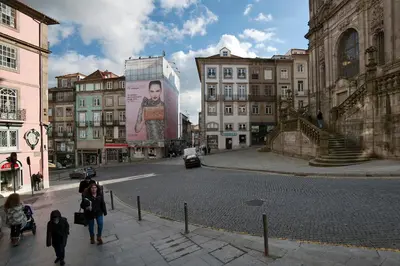 a group of people walking down a city street at YOUROPO - Clerigos in Porto