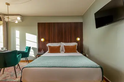 a bedroom with a bed and a desk with a chair at YOUROPO - Clerigos in Porto