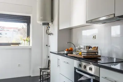 a kitchen with white cabinets and a counter top at KOPKE 113, local & spacious 2Bed in Porto
