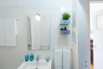 a white bathroom with a sink and a mirror at KOPKE 113, local & spacious 2Bed in Porto