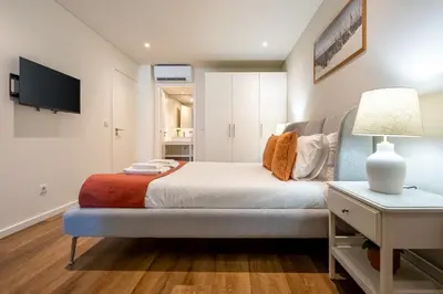 a bedroom with a bed and a table with a lamp at Sao Bento Luxury Hideaway 2 Bedroom Downtown Porto in Porto