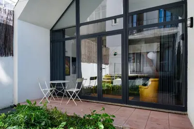 two chairs and a table in front of a building at Cool Alegria Loft Mezzanine Retreat in Porto
