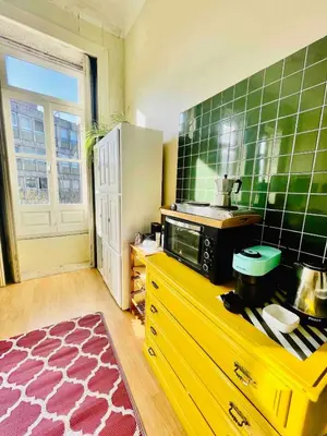 a kitchen with a yellow counter and green tiled wall at Ai Porto! Gold&Soul in Porto