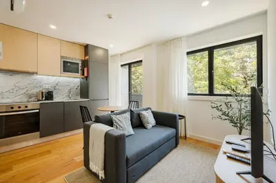 a living room with a blue couch and a kitchen at GuestReady - Gracious City Escape in Porto in Porto