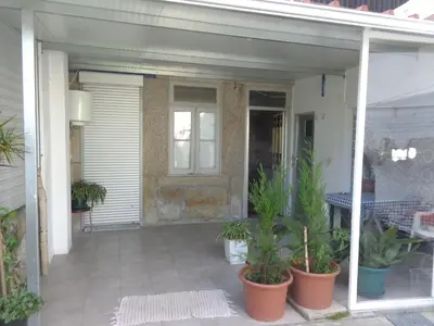 a porch of a house with potted plants on it at Portuense Alojamento Local in Porto