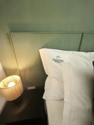 a vase filled with pink flowers next to a pillow at Best Deal Porto Apartment - Porto Velho Apt in Porto