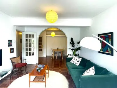 a living room with a green couch and a table at Your house in Porto in Vila Nova de Gaia